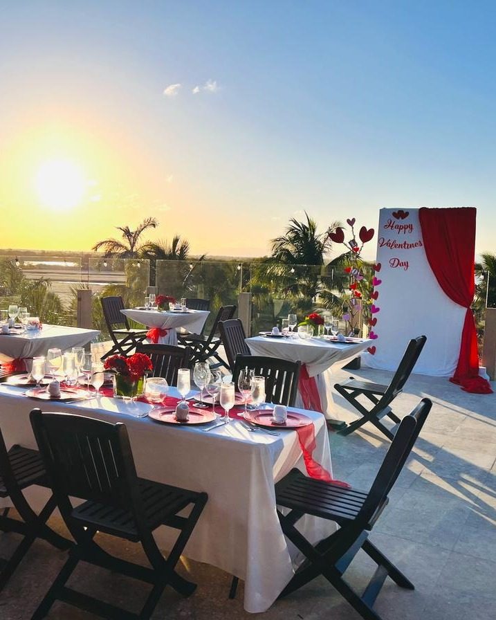 Rooftop dining setup at Inky’s Belize during sunset, with decorated tables, Valentine’s Day accents, and open-air views over the Placencia Peninsula.